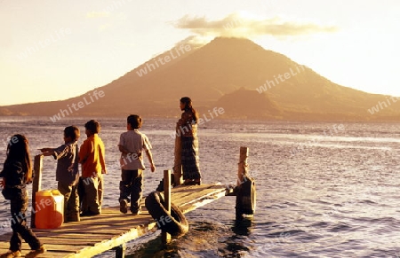 People at the coast of Lake Atitlan mit the Volcanos of Toliman and San Pedro in the back at the Town of Panajachel in Guatemala in central America.   