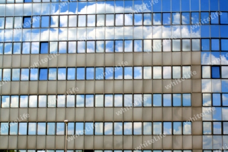 wolken spiegeln sich in einer glasfassade