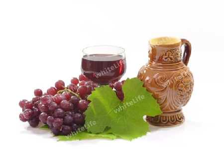 Rotwein mit roten Trauben auf hellem Hintergrund