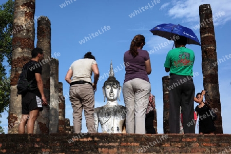 Touristen vor einer Buddha Figur  im Wat Mahathat Tempel in der Tempelanlage von Alt-Sukhothai in der Provinz Sukhothai im Norden von Thailand in Suedostasien.