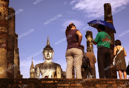 Touristen vor einer Buddha Figur  im Wat Mahathat Tempel in der Tempelanlage von Alt-Sukhothai in der Provinz Sukhothai im Norden von Thailand in Suedostasien.