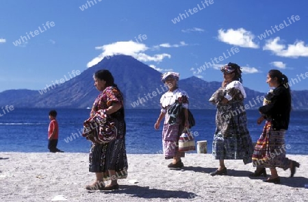 People at the coast of Lake Atitlan mit the Volcanos of Toliman and San Pedro in the back at the Town of Panajachel in Guatemala in central America.   