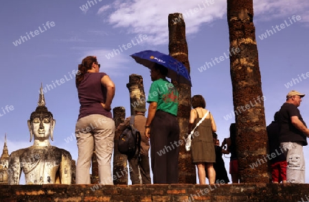 Touristen vor einer Buddha Figur  im Wat Mahathat Tempel in der Tempelanlage von Alt-Sukhothai in der Provinz Sukhothai im Norden von Thailand in Suedostasien.