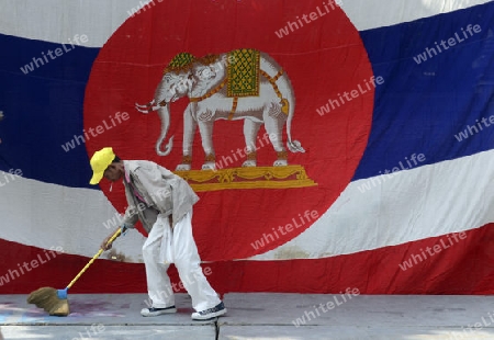 Ein Mann reinigt ein podium mit einer Thailaendischen Flagge im Stadtteil Banglangphu in der Hauptstadt Bangkok von Thailand in Suedostasien.