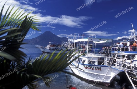 People at the coast of Lake Atitlan mit the Volcanos of Toliman and San Pedro in the back at the Town of Panajachel in Guatemala in central America.   