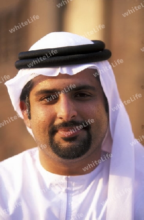 a portrait of a Arab men in the souq or Market in the old town in the city of Dubai in the Arab Emirates in the Gulf of Arabia.