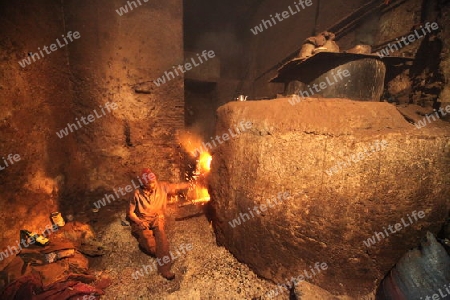 A men heat up Water for a Hammam or Arab Bath in the old City in the historical Town of Fes in Morocco in north Africa.