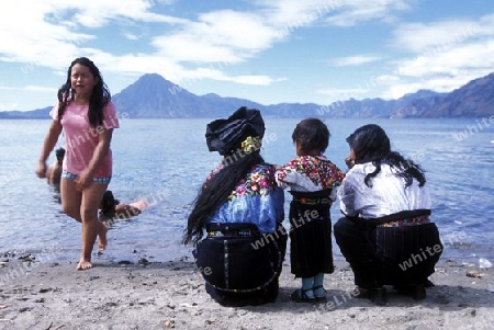 People at the coast of Lake Atitlan mit the Volcanos of Toliman and San Pedro in the back at the Town of Panajachel in Guatemala in central America.   