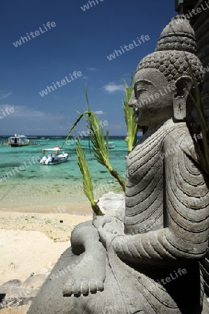 Ein Buddha Figur am Strand von Jungutbatu auf der Insel Nusa vor und in Bali in Indonesien in Asien.