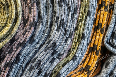 Detailed close up view on samples of cloth and fabrics in different colors found at a fabrics market.