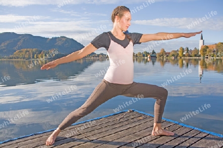 Junge Frau beim Yoga am See 