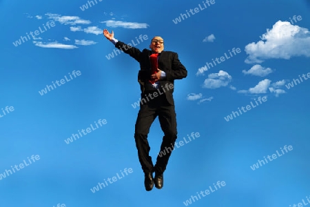 Man in suit with glasses jumping under a blue sky - Mann in Anzug mit Brille und Glatze unter blauem Himmel                               