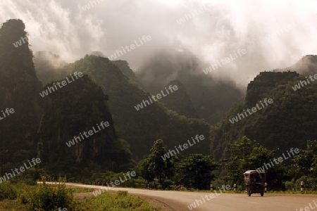 Die Landstrasse 12 beim Dorf Mahaxai Mai von Tham Pa Fa unweit der Stadt Tha Khaek in zentral Laos an der Grenze zu Thailand in Suedostasien.