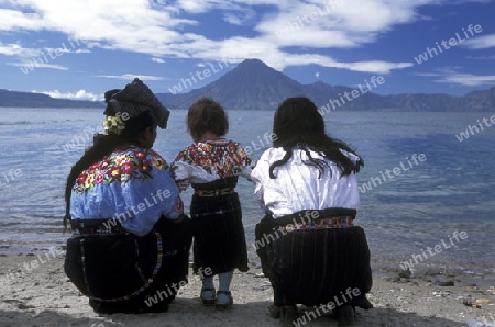 People at the coast of Lake Atitlan mit the Volcanos of Toliman and San Pedro in the back at the Town of Panajachel in Guatemala in central America.   