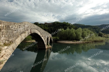 Die Landschaft mit der Steinbruecke von Rijeka Crnojevica mit dem Fluss Rijeka Crnojevica am westlichen ende des Skadarsko Jezero See oder Skadarsee in Zentral Montenegro in Montenegro im Balkan am Mittelmeer in Europa.