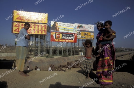 a Family in a slum and in front of promotions in the city of Bombay or Mumbai in India.