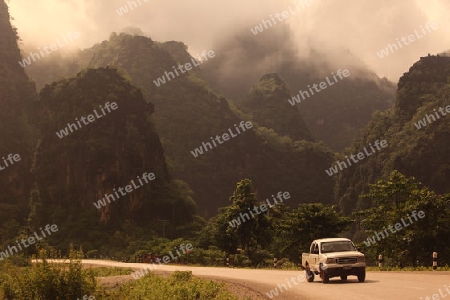 Die Huegellandschaft an der Landstrasse 12 zwischen der Stadt Tha Khaek und dem Dorf Mahaxai Mai in zentral Laos an der Grenze zu Thailand in Suedostasien.