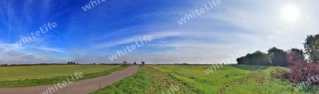 Beautiful high resolution panorama of a northern european country landscape with fields and green grass.