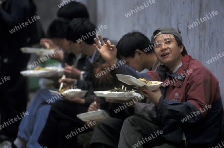 people with fast food on the Market streets of Chongqing in the province of Sichuan in china in east asia. 