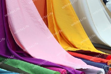 Detailed close up view on samples of cloth and fabrics in different colors found at a fabrics market.