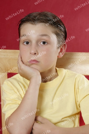 Sitting boy resting head on hand