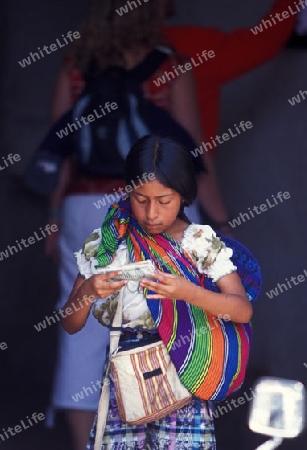 a child with money from tourists in the old town in the city of Antigua in Guatemala in central America.   