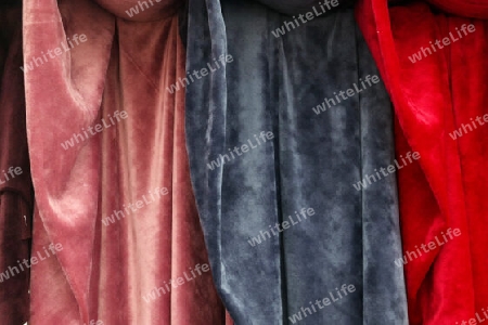 Detailed close up view on samples of cloth and fabrics in different colors found at a fabrics market.