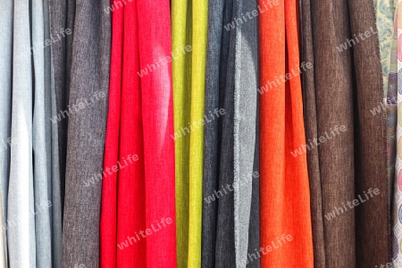 Detailed close up view on samples of cloth and fabrics in different colors found at a fabrics market.