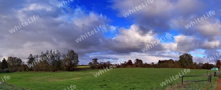 Beautiful high resolution panorama of a northern european country landscape with fields and green grass.