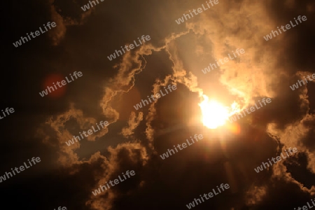 Sonnen und Wolkenspiel ueber der Landstrasse 12 zwischen der Stadt Tha Khaek und dem Dorf Mahaxai Mai in zentral Laos an der Grenze zu Thailand in Suedostasien.