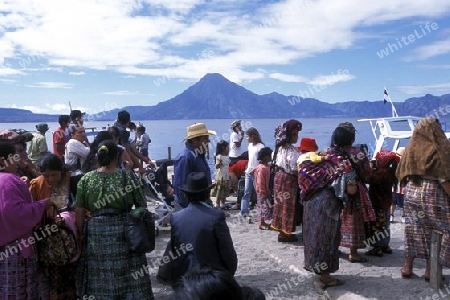 People at the coast of Lake Atitlan mit the Volcanos of Toliman and San Pedro in the back at the Town of Panajachel in Guatemala in central America.   