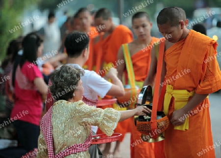 Moenche am fruehen Morgen beim einsammeln von Reis in der Altstadt von Luang Prabang in Zentrallaos von Laos in Suedostasien. 