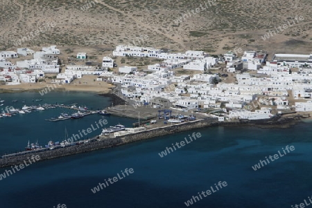 The  Isla Graciosa with the village of Caleta del Sebothe from the Mirador del Rio viewpoint on the Island of Lanzarote on the Canary Islands of Spain in the Atlantic Ocean. on the Island of Lanzarote on the Canary Islands of Spain in the Atlantic Oc