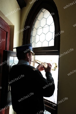 Der Turmblaeser bei einem Trompetensignal auf dem Turm der Marienkirche in der Altstadt von Krakau im sueden von Polen.