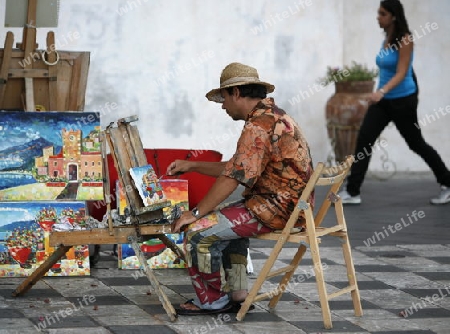 a Painter in the old Town of  Taormina in Sicily in south Italy in Europe.