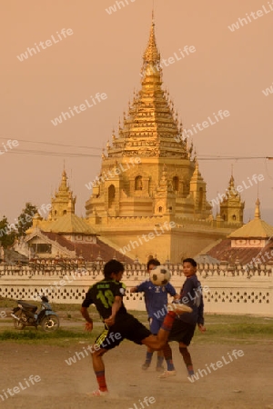 soccer player in soccer field in front of the Yadana Man Aung Pagoda in the town of Nyaungshwe at the Inle Lake in the Shan State in the east of Myanmar in Southeastasia.