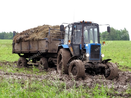 Traktor mit Anhaenger im Schlamm