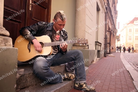 Ein Strassenmusiker in einer Gasse in der Altstadt in Riga, Lettland  