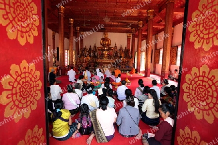 Menschen in einem Tempel  in der Altstadt von Luang Prabang in Zentrallaos von Laos in Suedostasien.  