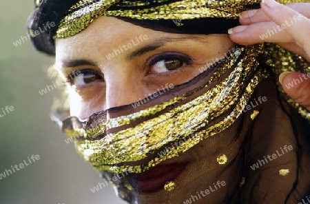 Eine Tunesische Frau in traditionellem Kopftuch  in Monastir am Mittelmeer im Nordosten von Tunesien in Nordafrika.