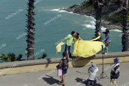 Ein Hochzeitspaar bei einem Fototermin am Aussichtspunkt Kap Promthep bei der Rawai Beach im sueden der Insel Phuket im sueden von Thailand in Suedostasien.