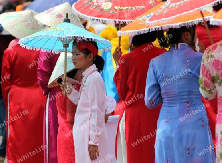 Menschen mit Papierschirmen an der Festparade beim Bun Bang Fai oder Rocket Festival in Yasothon im Isan im Nordosten von Thailand. 