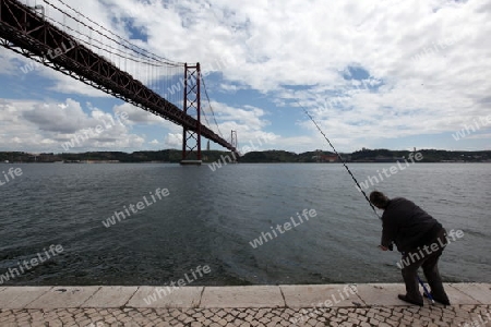 Ein Fischer bei der Bruecke Ponte 25 de Abril im Stadtteil Belem der Hauptstadt Lissabon in Portugal.       