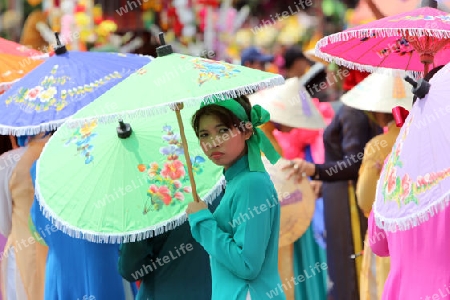 Menschen mit Papierschirmen an der Festparade beim Bun Bang Fai oder Rocket Festival in Yasothon im Isan im Nordosten von Thailand. 