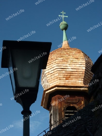 Holzkirche mit Zwiebelturm neben Laterne