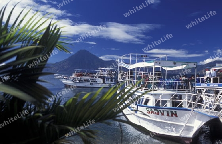 People at the coast of Lake Atitlan mit the Volcanos of Toliman and San Pedro in the back at the Town of Panajachel in Guatemala in central America.   