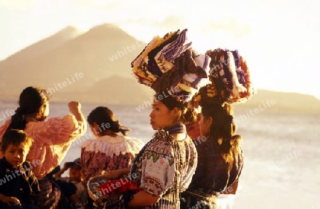 People at the coast of Lake Atitlan mit the Volcanos of Toliman and San Pedro in the back at the Town of Panajachel in Guatemala in central America.   