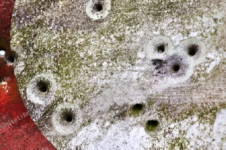 Detailed close up of bullet holes from gun shots in a german traffic sign