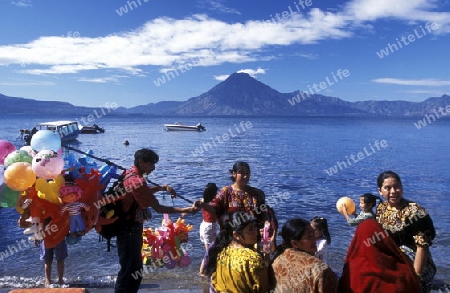 People at the coast of Lake Atitlan mit the Volcanos of Toliman and San Pedro in the back at the Town of Panajachel in Guatemala in central America.   