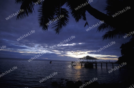 Ein Hotelstrand mit Pavillon bei Sonnenuntergang auf der Insel Praslin auf den Seychellen im Indischen Ozean.